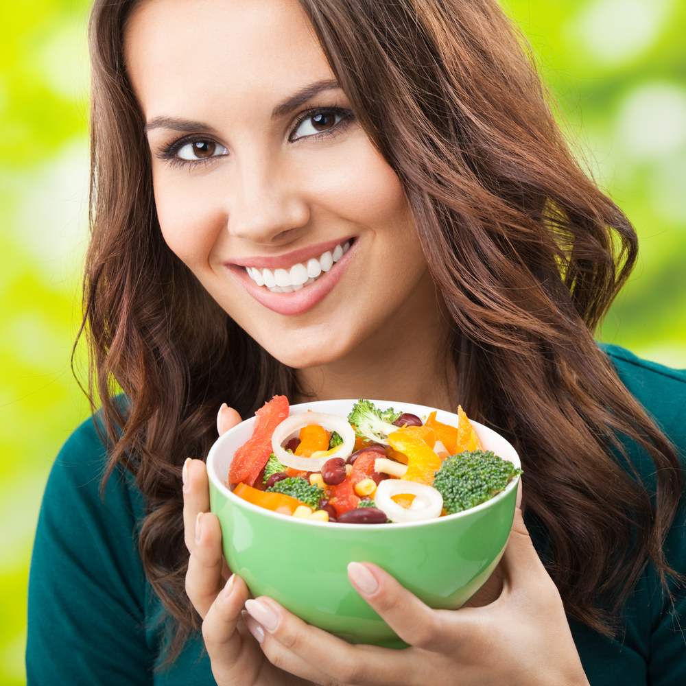 young woman eating a salad full of nutrition